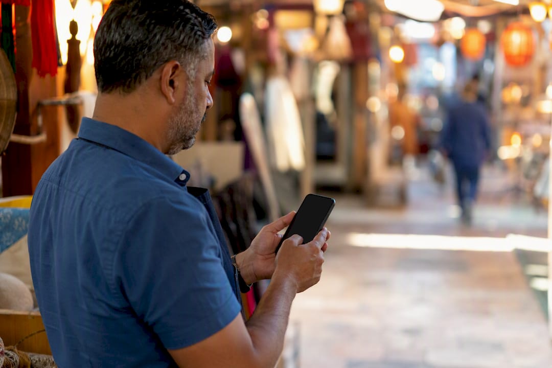 Business owner sending SMS review request on smartphone