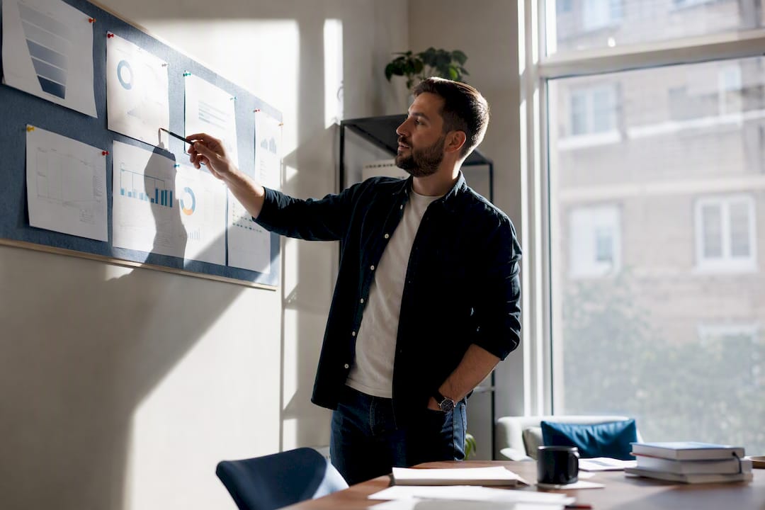 Business owner monitoring marketing funnel charts on wall